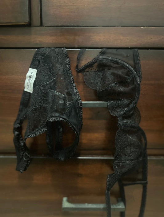 Black embroidered lace lingerie set on a wooden surface